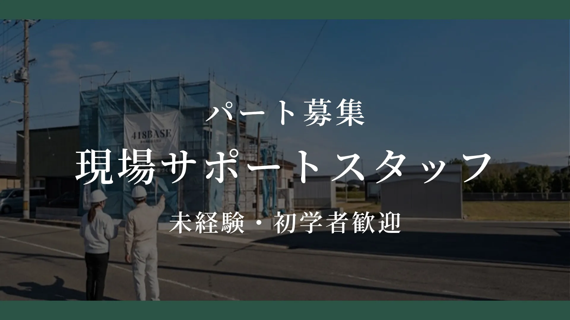 足場のかかった建築中の住宅の前で、現場監督とスタッフが打ち合わせをしている様子